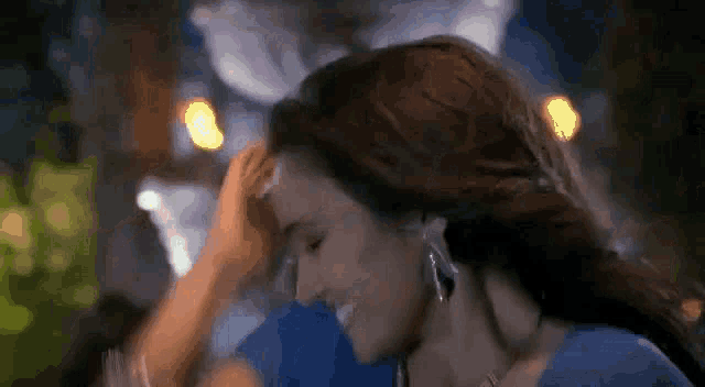a woman in a blue dress is dancing with a man in a blue shirt .