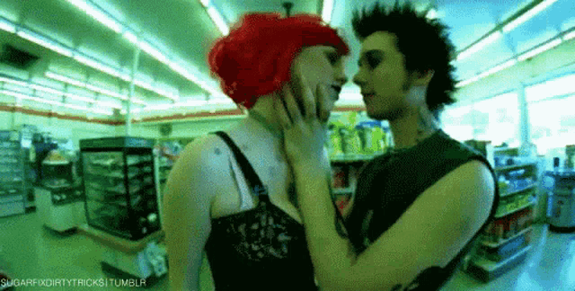 a man and a woman are kissing in a store . the woman has red hair .
