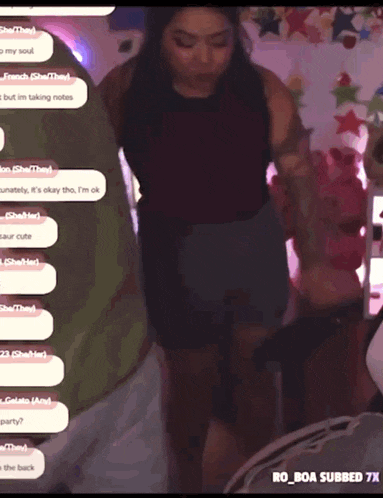 a woman standing in front of a screen that says ro_boa subbed 7x on it