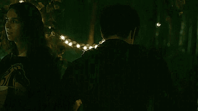 a man is drinking from a glass in a forest .