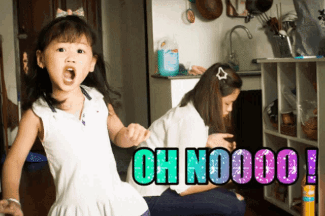 a little girl is standing in front of a sign that says oh nooooo
