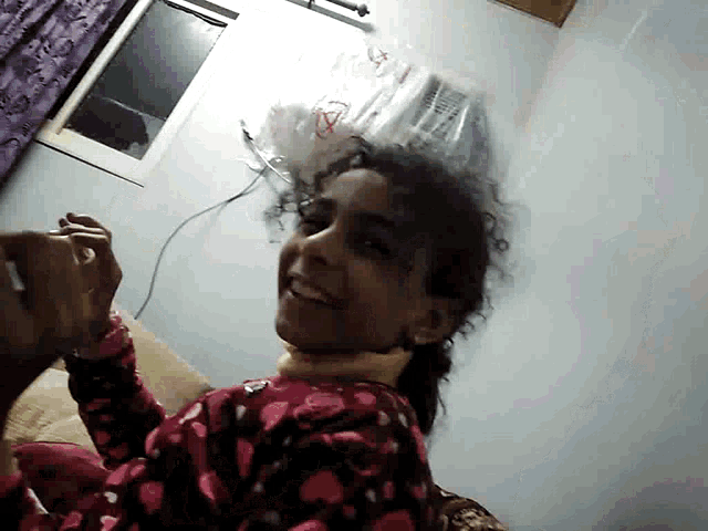 a woman in a pink pajama top is upside down in a room