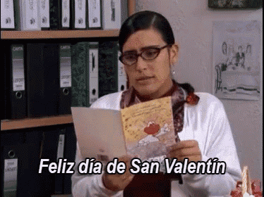 a woman is holding a card that says feliz dia de san valentin on it
