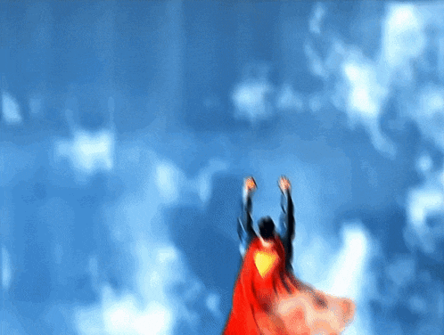 a man in a superman cape is flying through a blue sky