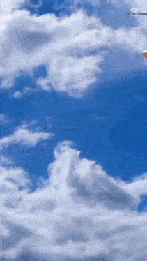 a plane is flying through a cloudy blue sky with the letter m visible