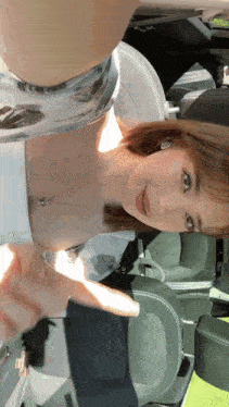 a woman is taking a selfie in the back seat of her car