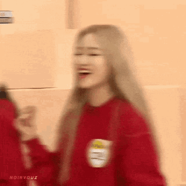 a woman in a red sweater is laughing and dancing .