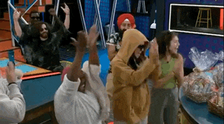 a group of people are dancing in a room with their arms in the air .