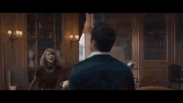 a man and a woman are having a fight in a room .