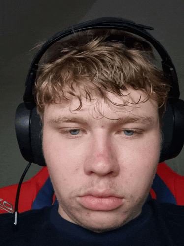 a young man wearing headphones has a red spot on his forehead