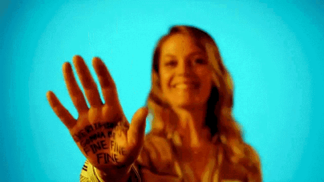 a woman is holding up her hand with the words `` one fine fine '' painted on it .