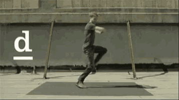 a man is doing a trick on a mat with the letter d above him