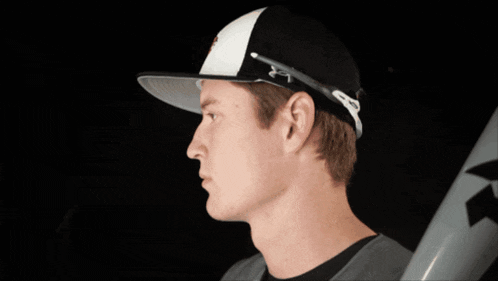 a baseball player wearing a hat and holding a bat with the letter k on it