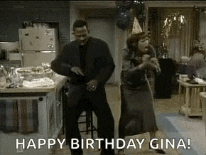 a man and a woman are dancing in a living room with balloons .