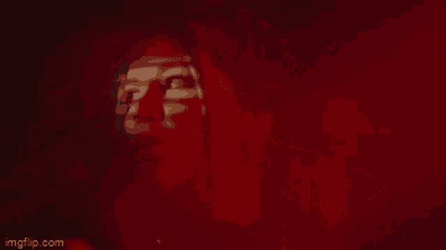 a blurry picture of a woman 's face in red light