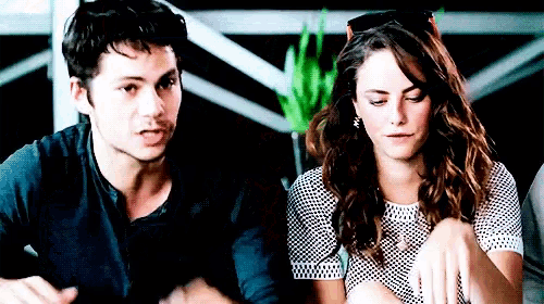 a man and a woman are sitting next to each other and looking at something .