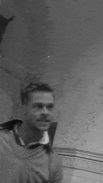 a black and white photo of a man smiling