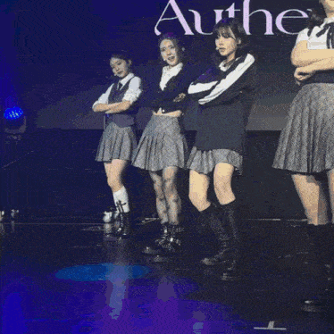 a group of girls are performing on a stage with the word au behind them