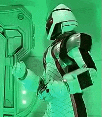 a man in a robot costume is standing in front of a green wall .
