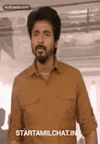 a man with a beard is standing in front of a sign that says starttamilchat in