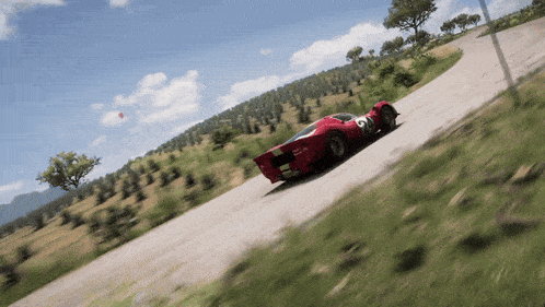 a red race car with the number 26 on the side is driving down a road