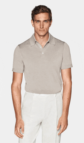 a man is wearing a light blue polo shirt and white pants