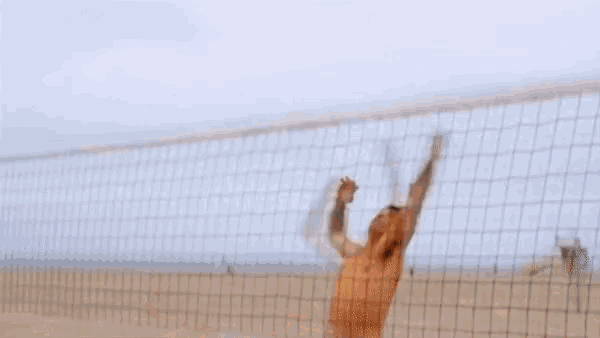 a shirtless man in camouflage shorts stands on a beach