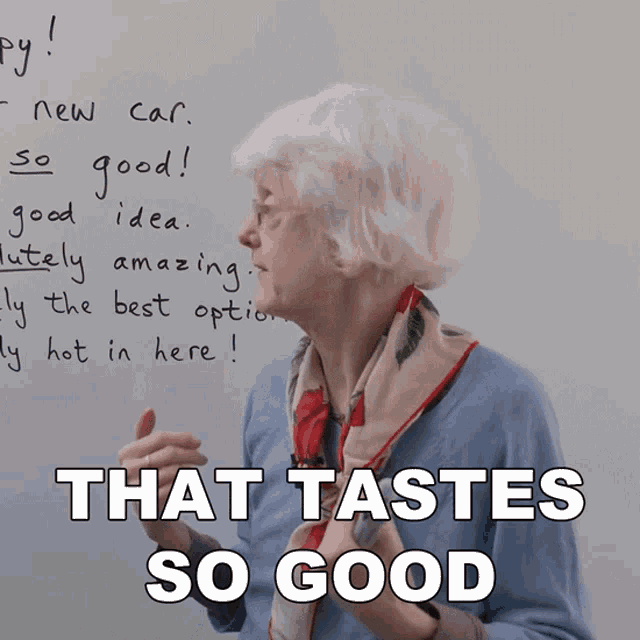 an elderly woman stands in front of a whiteboard with the words that tastes so good written on it