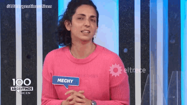 a woman in a pink sweater has a name tag that says mechay