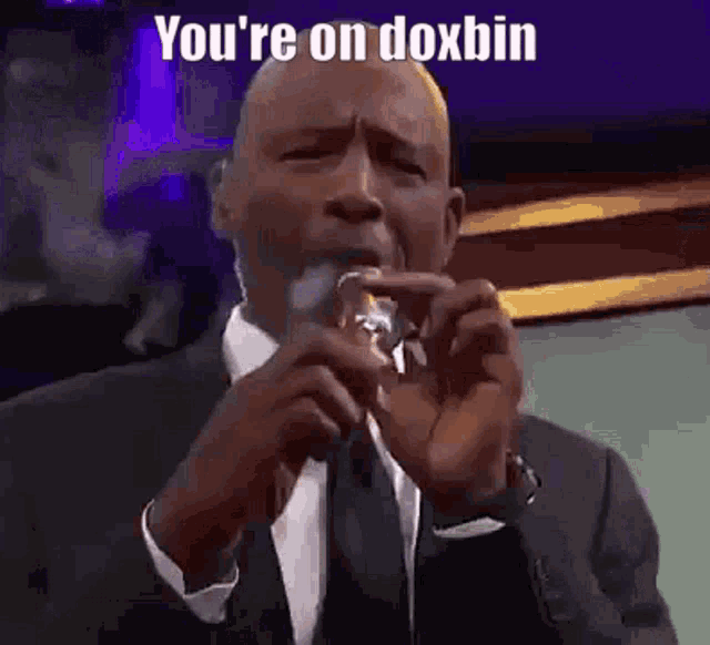 a man in a suit and tie is holding a glass in his hand and saying you 're on doxbin .