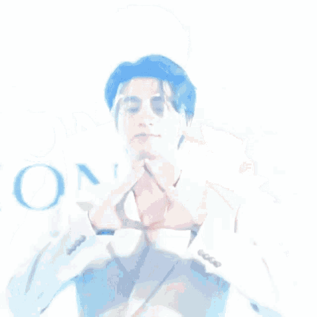 a man in a suit making a heart shape with his hands .
