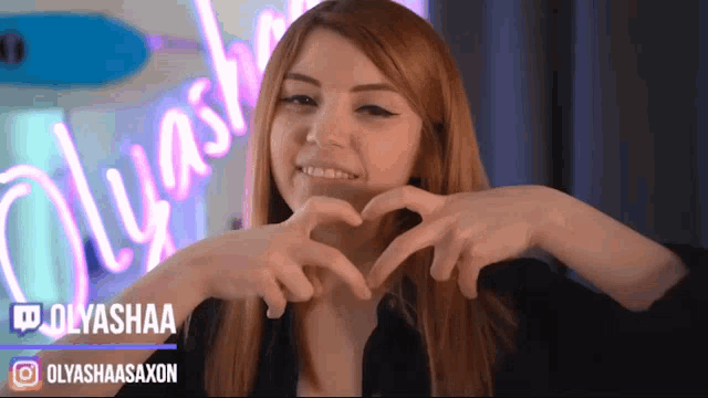 a woman making a heart shape with her hands with the name olyashaa on the bottom