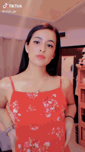 a woman in a red floral dress has a tiktok watermark