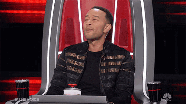 a man is sitting in a chair with a nbc logo on the bottom