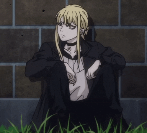 a girl with blonde hair is sitting in the grass