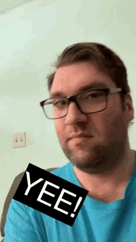 a man wearing glasses and a blue shirt with a yee sticker on his face