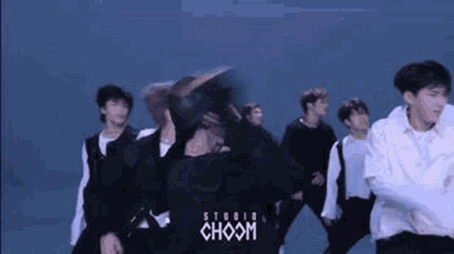 a group of young men are dancing together in a room .