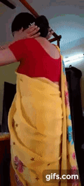 a woman wearing a yellow saree and a red blouse