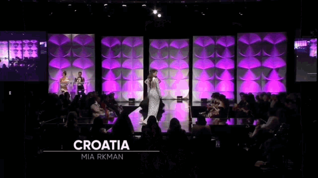 a woman in a black dress with a croatia sash on her chest