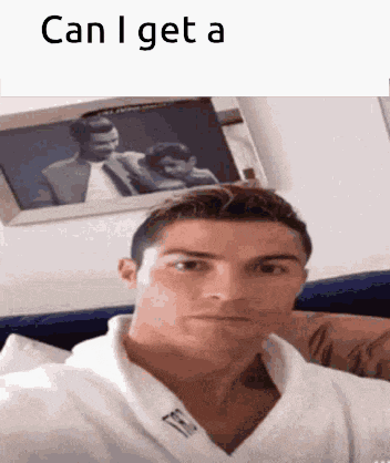 a man in a white robe is taking a selfie in front of a picture of a man and woman .