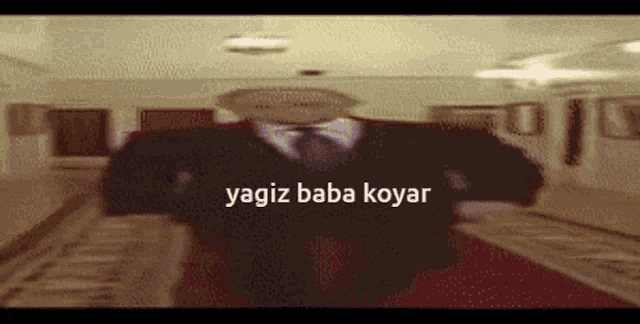 a blurry picture of a man in a suit and tie with the words yagiz baba koyar on the bottom right