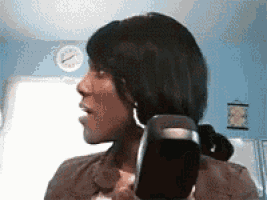 a woman is talking on a cell phone in front of a wall clock