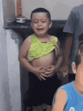 a young boy in a yellow shirt is crying