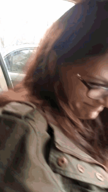 a close up of a woman wearing glasses and a jacket