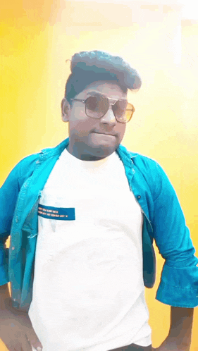 a young man wearing sunglasses and a white shirt with a blue jacket