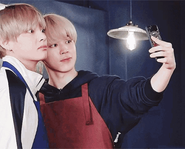 two young men are taking a selfie with their cell phones and one of them has a case that says supreme