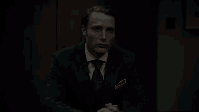 a man in a suit and tie is sitting at a table and asking is that right .