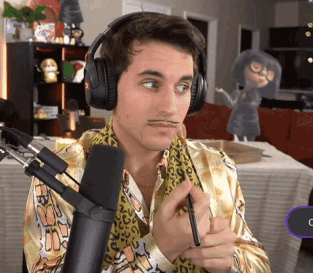 a man wearing headphones and a leopard print shirt is holding a pen