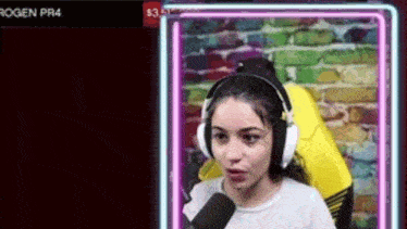 a woman wearing headphones and a microphone is sitting in front of a neon sign .