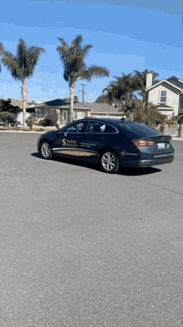 a black car with a sticker on the side that says ' s house realty ' on it